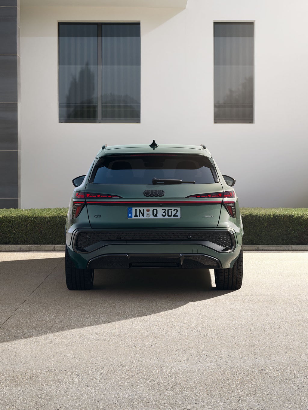 Audi Q3 SUV back view, parking in front of an house.
