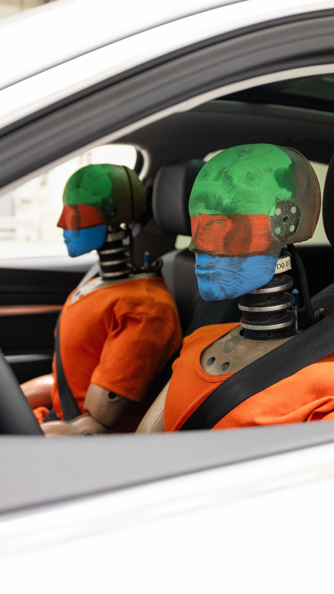 Auf dem Fahrer- und Beifahrersitz eines Audi sitzen zwei Dummys für einen Crash-Test