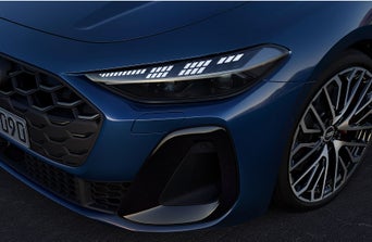Close-up of a dark blue car showcasing sleek LED headlights, an elegant grille, and a stylish alloy wheel.