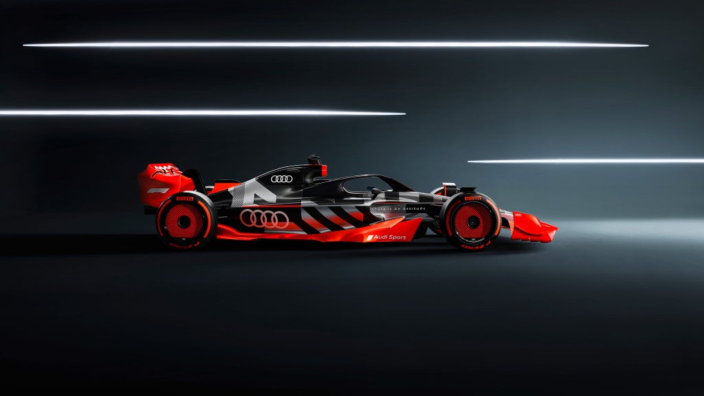 Ett konceptfordon av en Audi racingbill visas från sidan med mörk bakgrund med tre ljusa streck. 