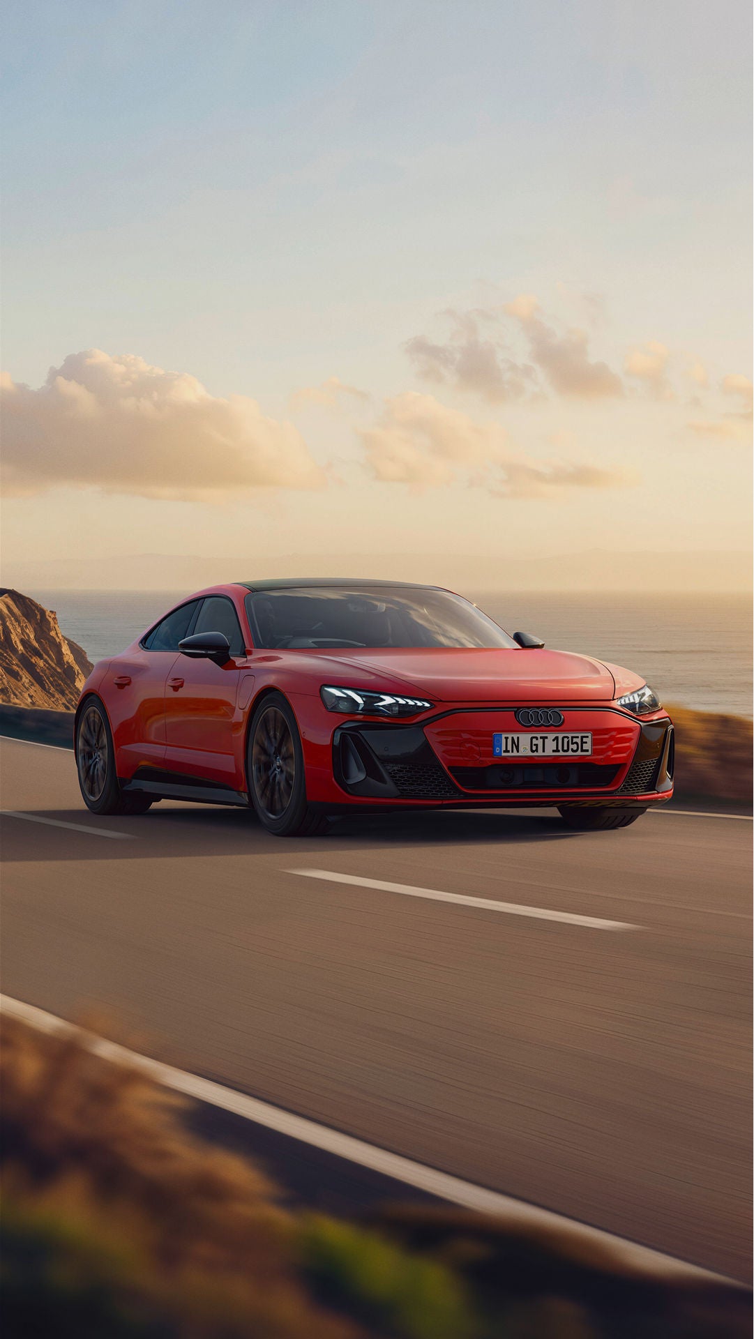 Red Audi e-tron GT quattro driving on a coastal road
