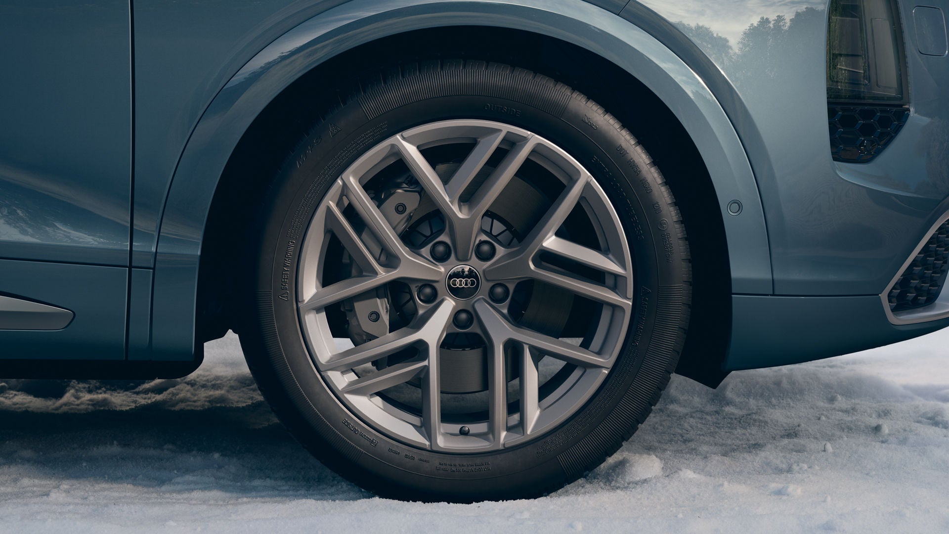 Gros plan sur une roue Audi équipée de jantes en alliage de 21 pouces au design « Tripod » à 5 branches, de couleur gris platine.