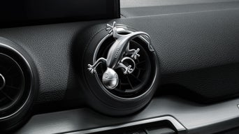 Ein Designgecko in Aluminiumoptik an der Lüftung in einem Audi.
