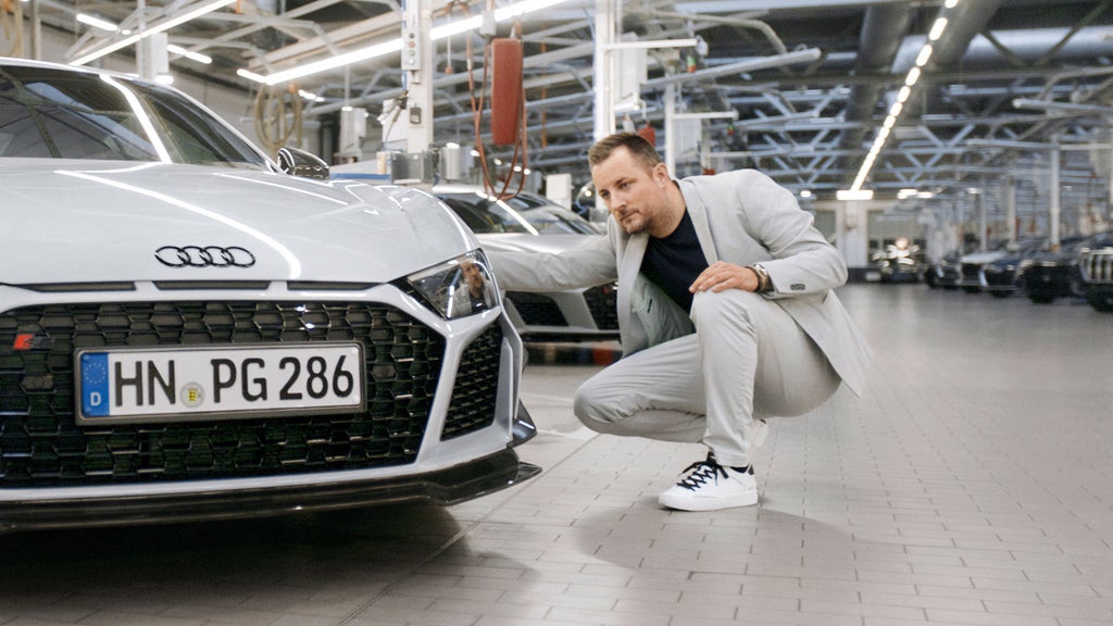 Dr. Sebastian Grams crouching next to the Audi R8 GT