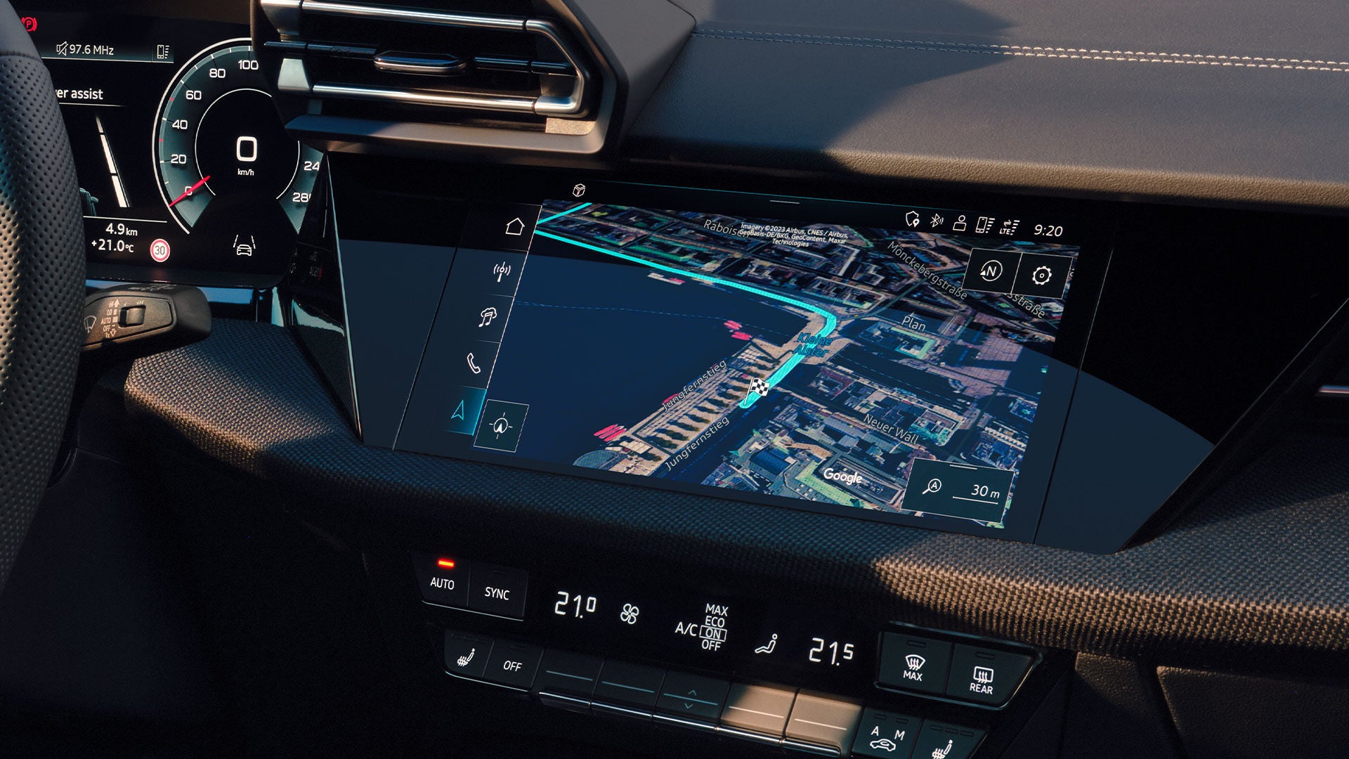 Zentraldisplay im Auto zeigt eine 3D-Navigationskarte mit Routenführung entlang eines Hafenareals auf Google Maps.