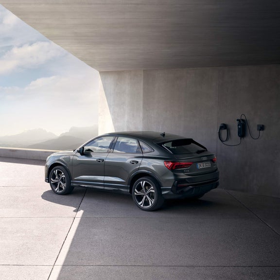 Rear view of Audi Q3 on the roof near a charging point.