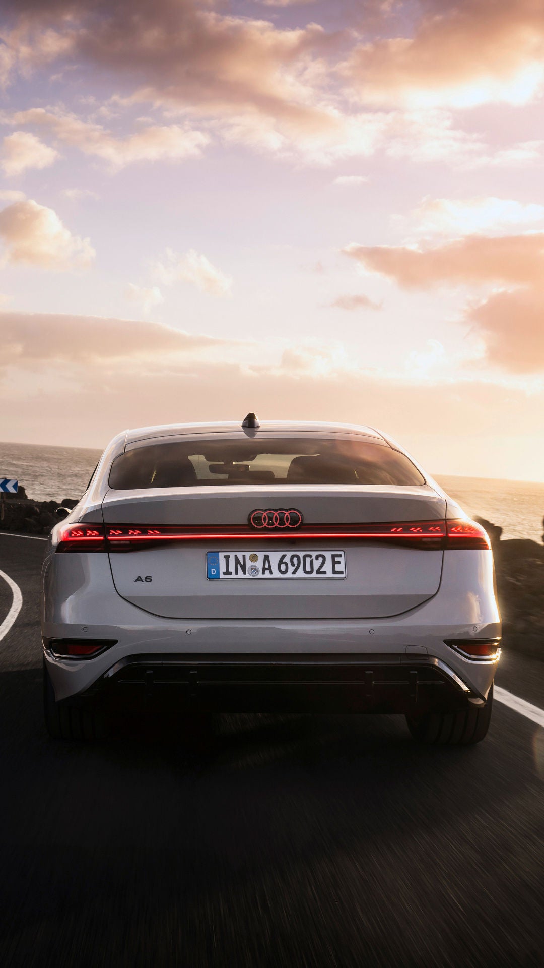 Audi A6 e-tron driving on a country road at sunset