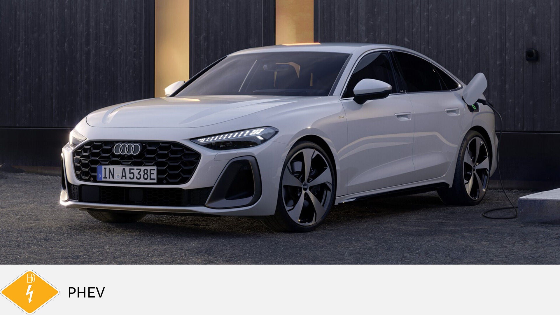 Weißer Audi A5 TFSI e an Ladestation vor dunkler Wand mit moderner Beleuchtung. Unten gelbes PHEV-Symbol mit Zapfsäule und Blitz.