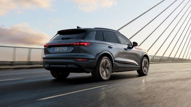 Der SQ6 SUV e-tron aus schräger Heckperspektive fährt über eine Brücke.