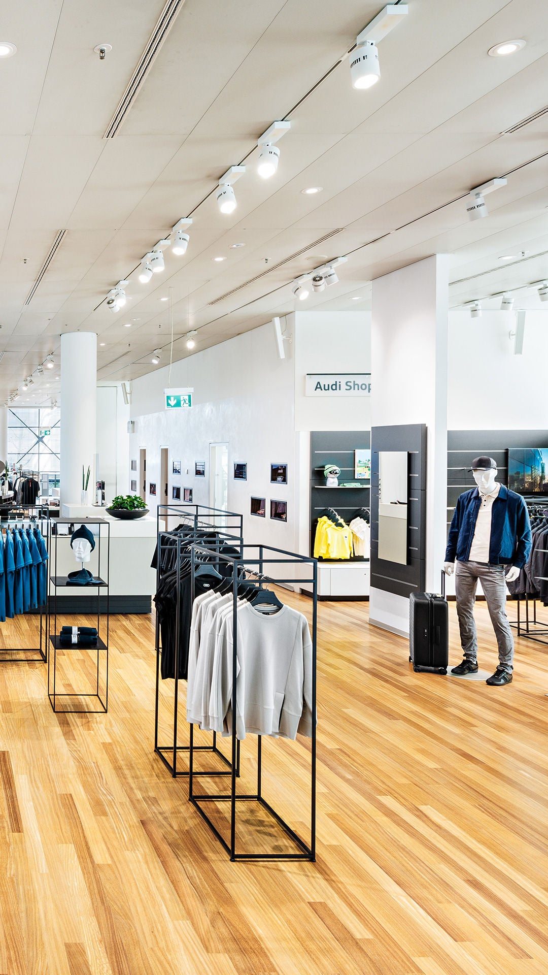 Innenansicht des Audi Shop mit Kleidung, Taschen und weiteren Accessoires.