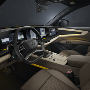 Blick in das Cockpit des Q9 SUV von der Fahrerseite. Der Innenraum erscheint dabei in gelblichem Ambiente-Licht.