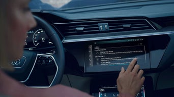 Kobieta za kierownicą obsługuje nawigację MMI Navigation plus w Audi