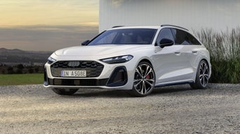 A5 Avant e-hybrid står i en vinkel framför en vit träfasad på en grusbelagd yta.