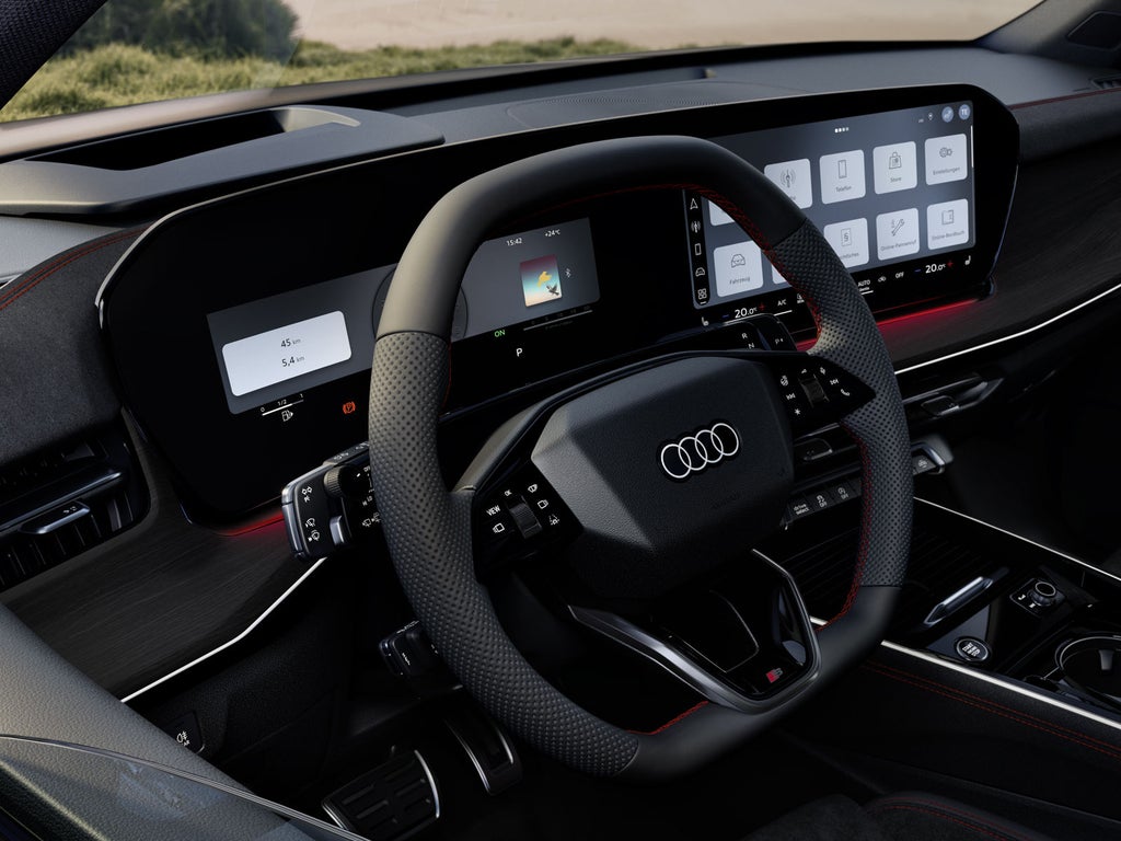 Blick von vorne auf das Lenkrad, Mittelkonsole und digitale Displays.