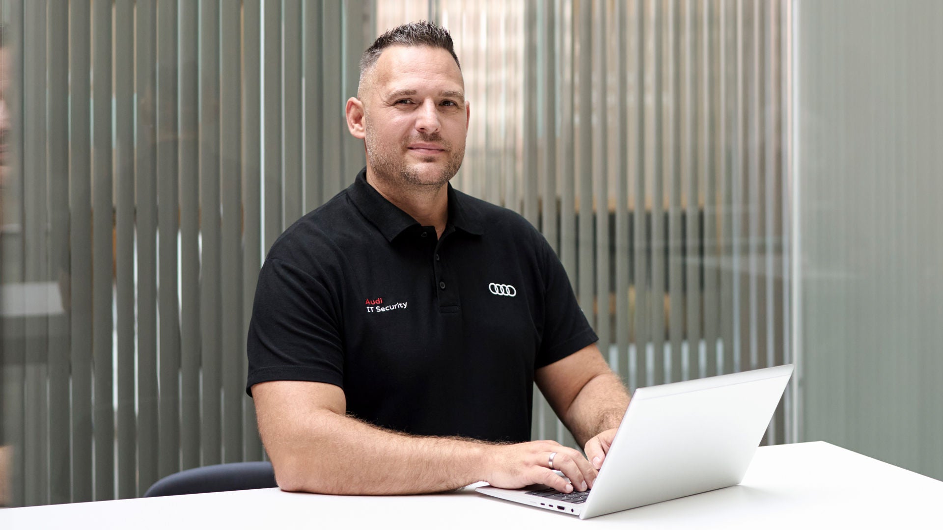 Andreas Walter looks into the camera and has a laptop in front of him