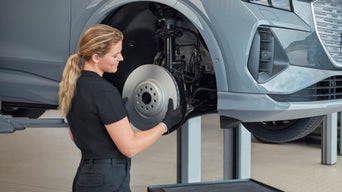 Audi service professional replacing brake discs
