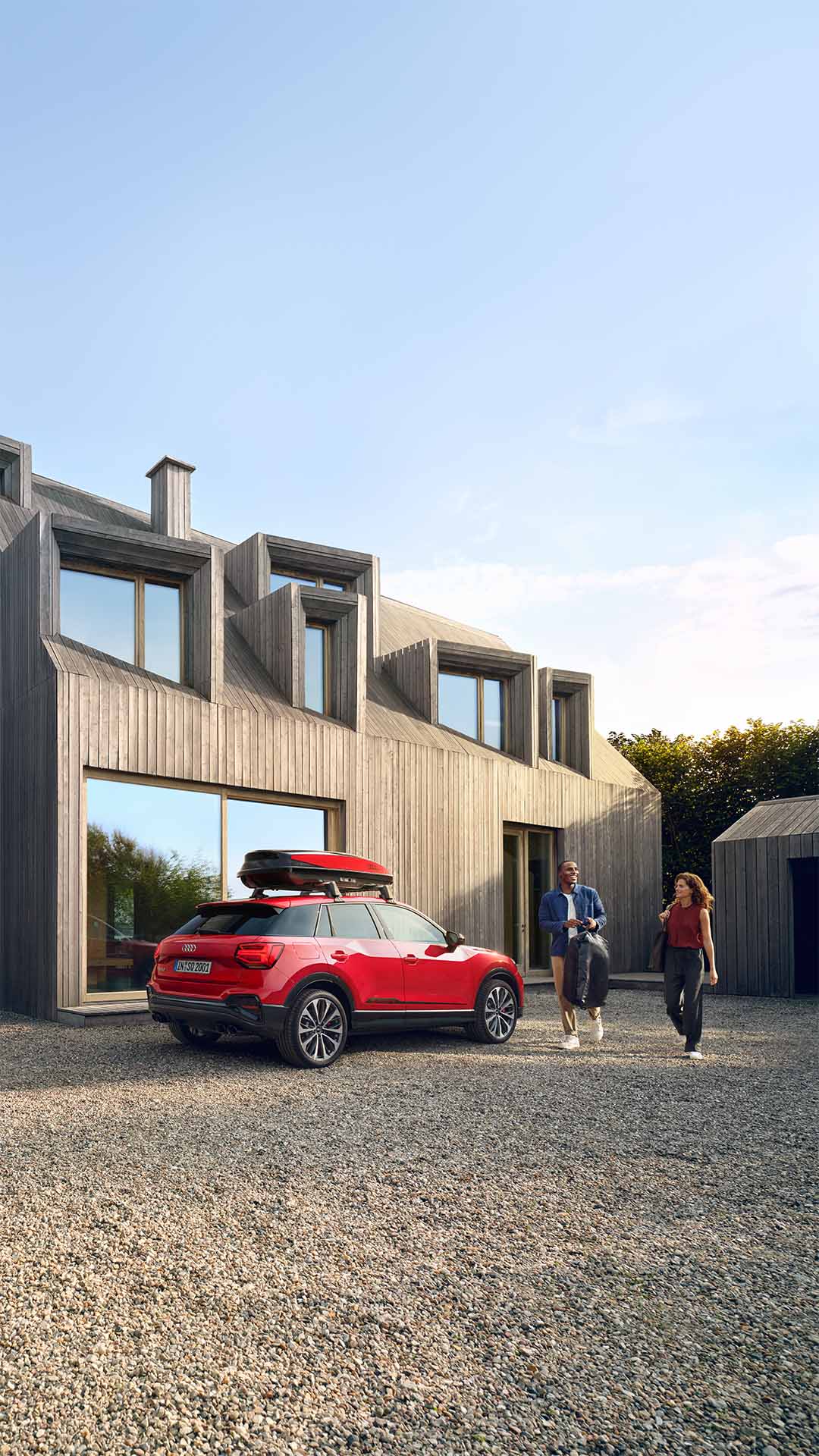 Et par går mot en Audi Q2 som står parkert utenfor huset.