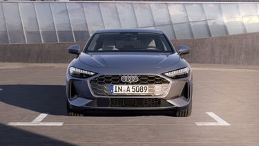 Die A5 Limousine steht im Frontprofil auf einem Parkplatz.