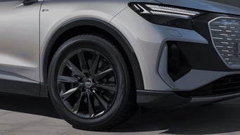 Close-up of an Audi's wheel and fender, featuring sleek black alloy wheels.