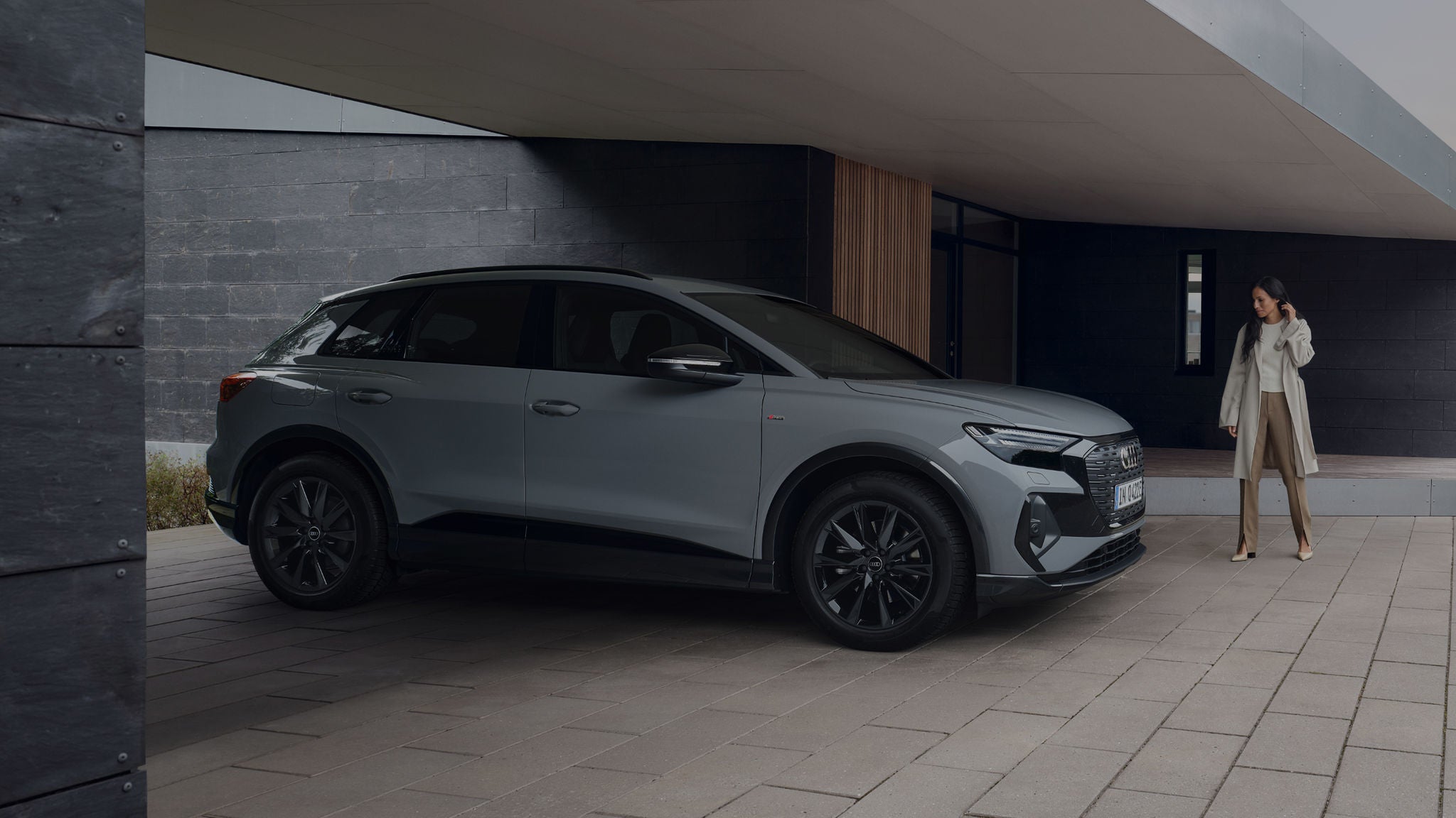 A woman walking towards a Q4 e-tron