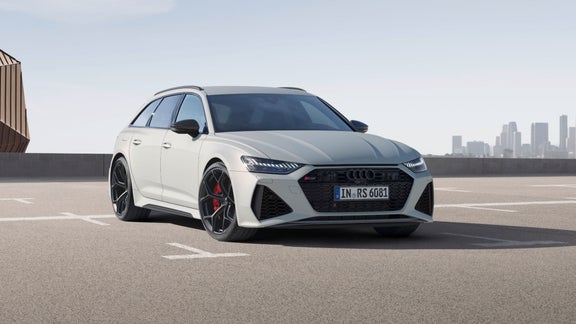 A white car parked with a city skyline in the background.