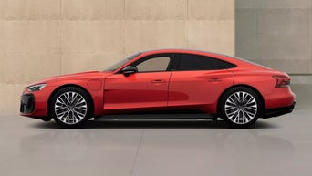 An Audi S e-tron GT parked against a modern, minimalist backdrop of beige walls, showcasing its contemporary design and smooth lines.