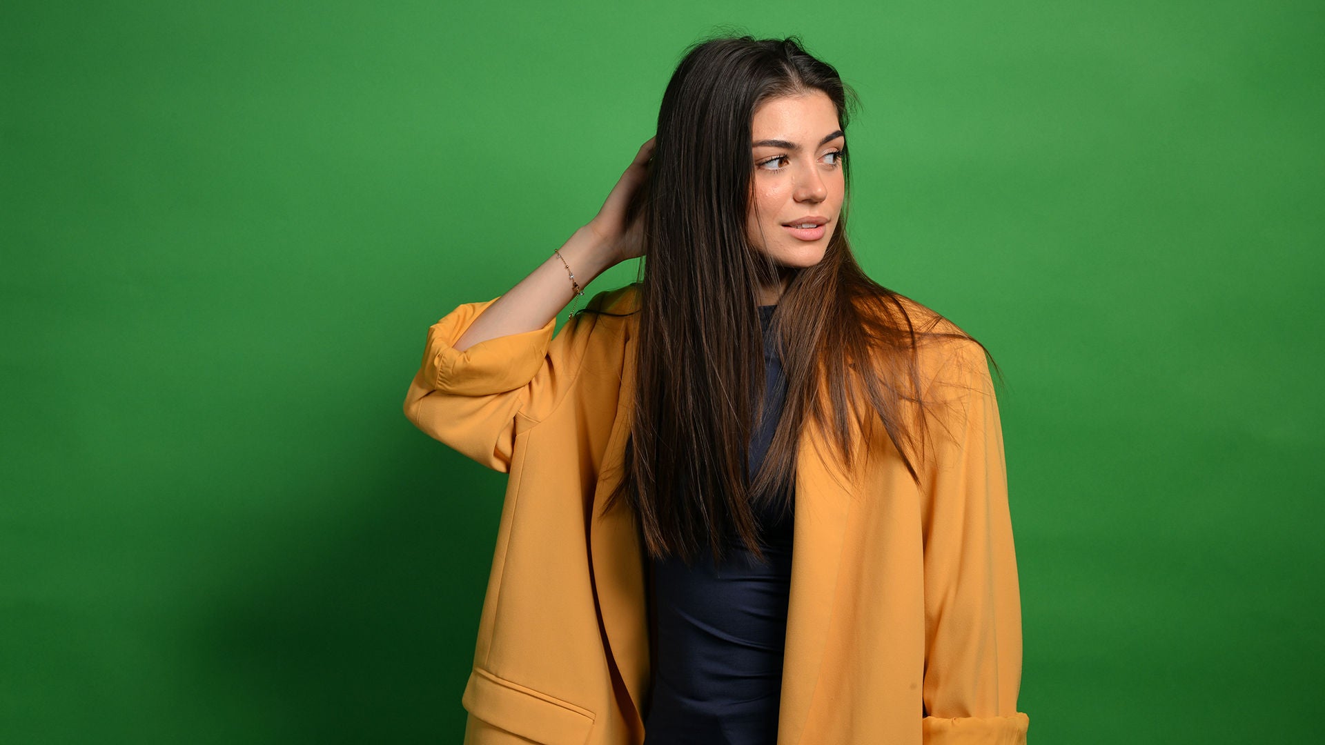 Emilia hat ihre rechte Hand in ihrem Haar und schaut nach links