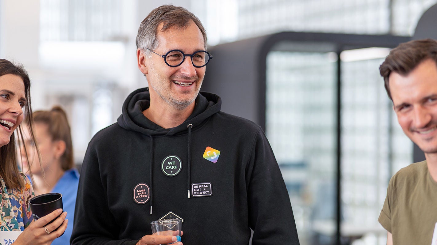 Person im Hoodie mit Glas in der Hand