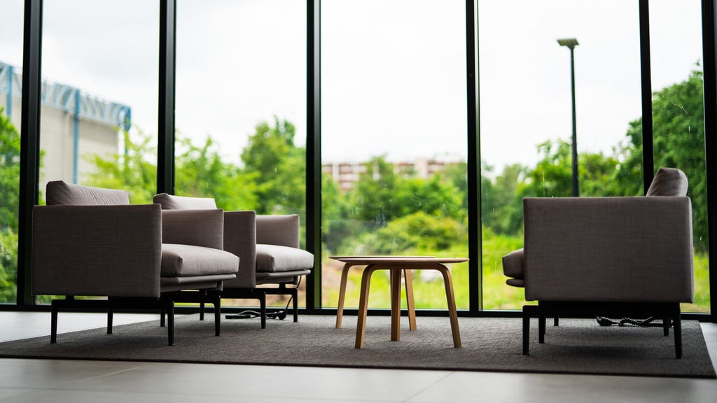 Seating in front of a window front with a view of the greenery