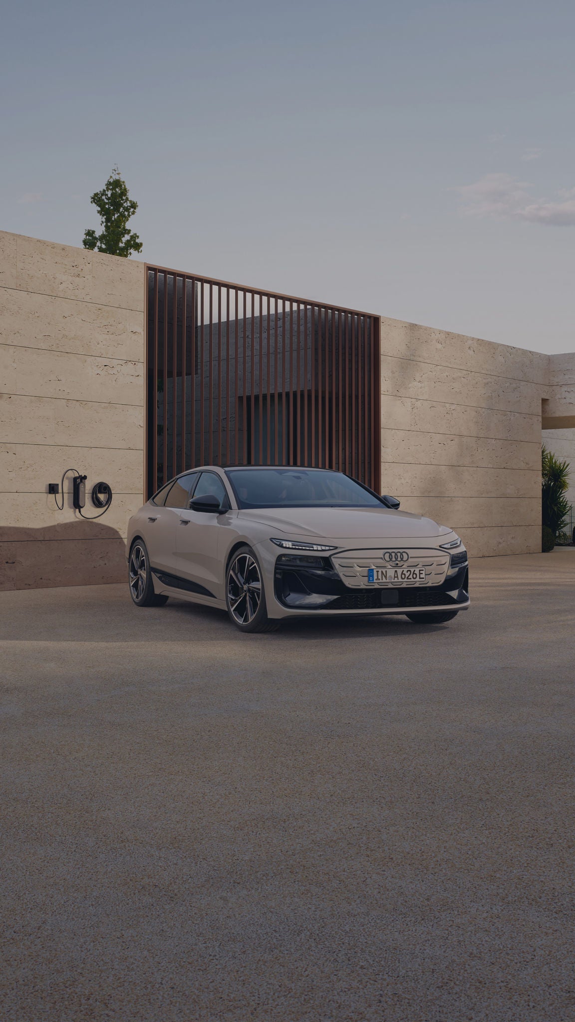 Audi A6 Sportback e-tron parked near a EV wall charger in modern settings.