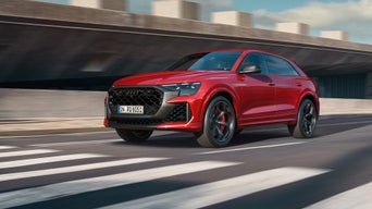 Roter Audi RS Q8 SUV performance fährt auf städtischer Straße.
