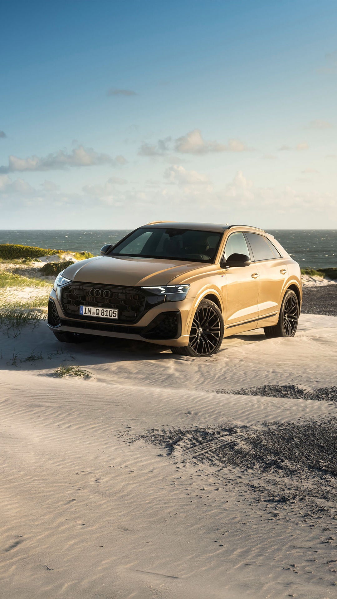 Audi Q8 SUV eestvaates pargitud mere äärde osaliselt liival