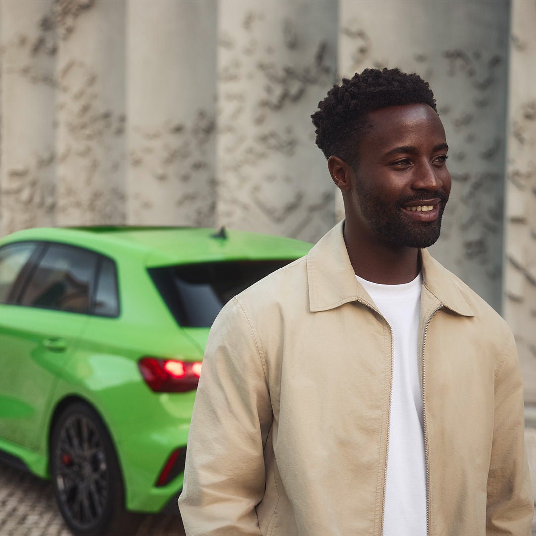 Man stood in front of green car