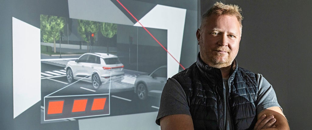 Porträt von Thomas Bleier neben einer Darstellung zur Fahrzeugsicherheit
