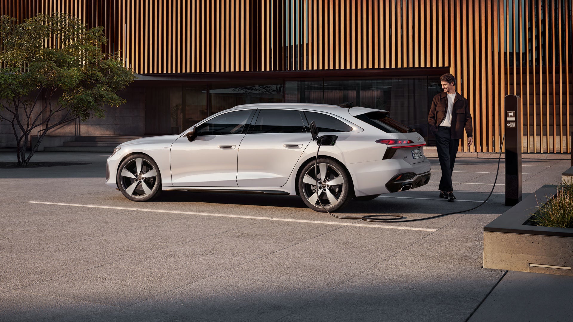 De A6 avant e-hybrid voor een moderne woning aan een laadpaal