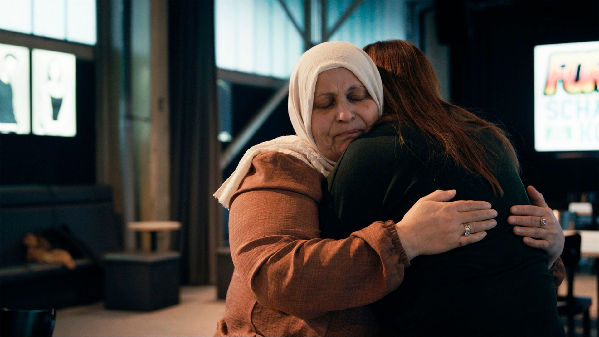 Die Geschwister von İbrahim umarmen sich in einem Bahnhof.