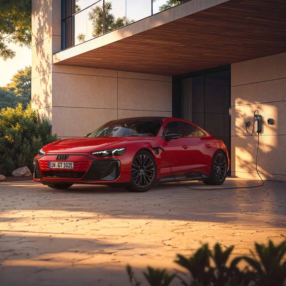 Audi e-tron GT quattro som lader foran et hus