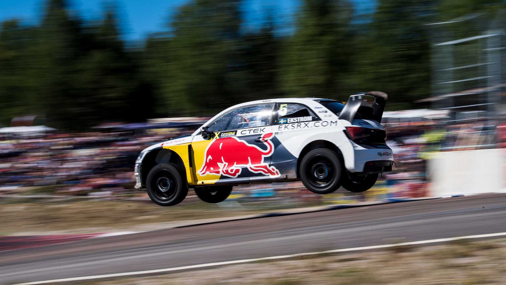 A picture showing an Audi rallycross car during a jump on track.