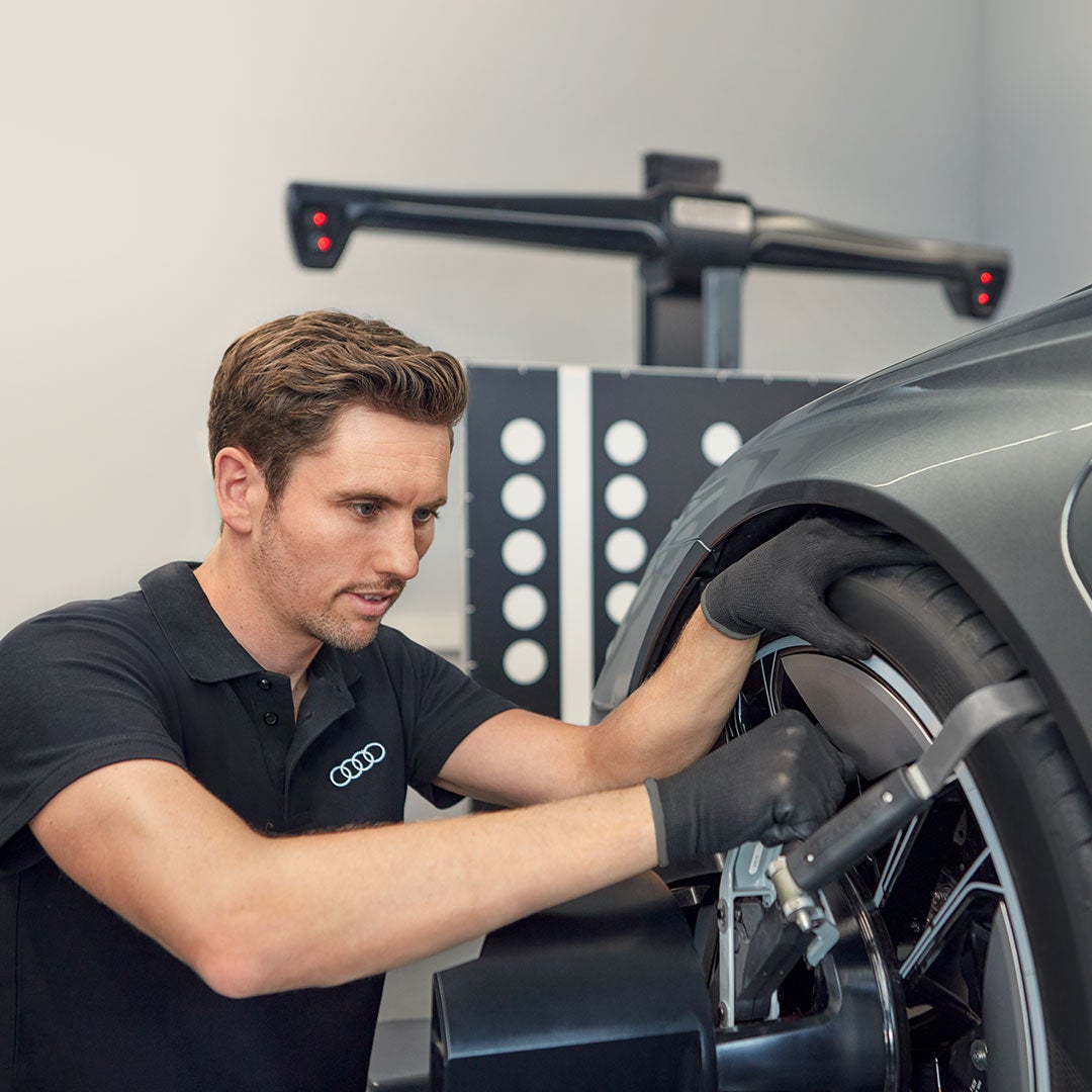 Audi Mitarbeiter überprüft Rad in der Werkstatt