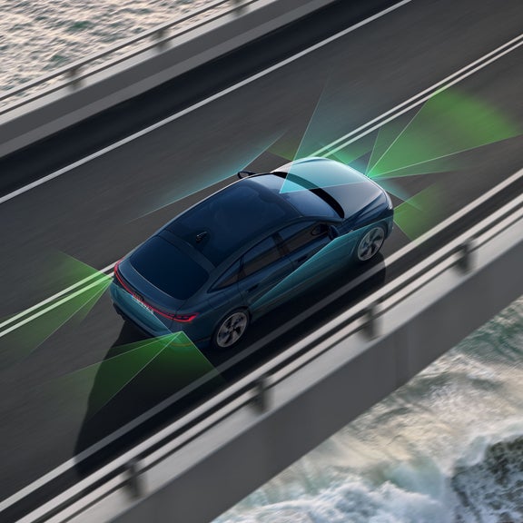 Der A6 Sportback e-tron von schräg oben. Vom Heck und der Front aus unterteilen grüne und blaue Vektoren die Flächen hinter und vor dem Fahrzeug.