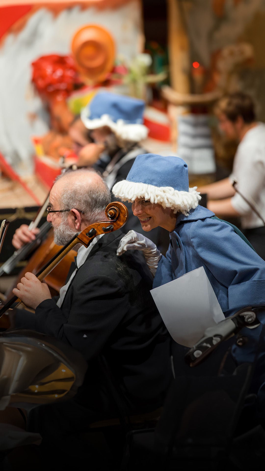 Kostümierte Frau amüsiert sich auf Bühne.