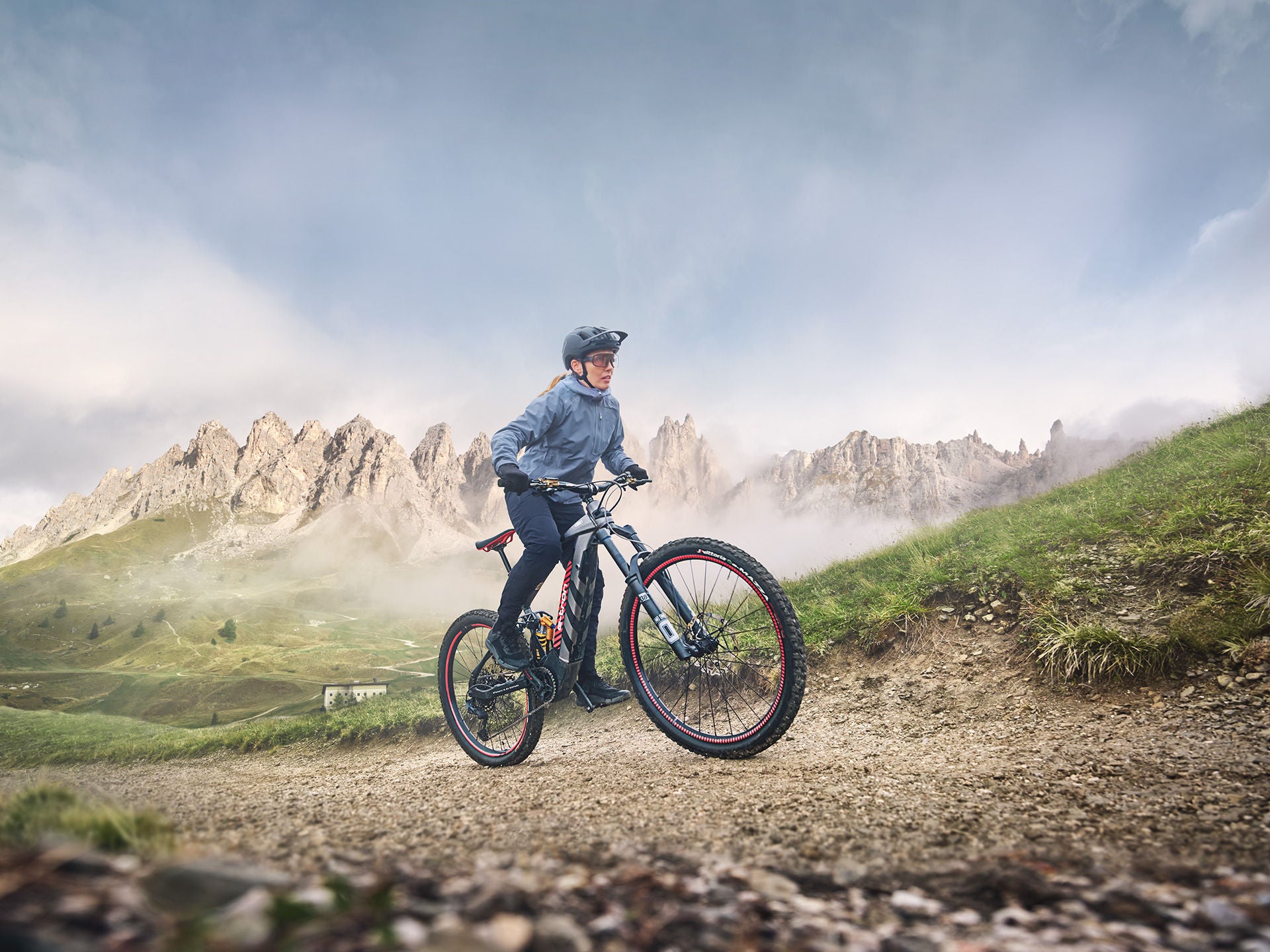 Woman riding up the hill on her Audi electric mountain bike