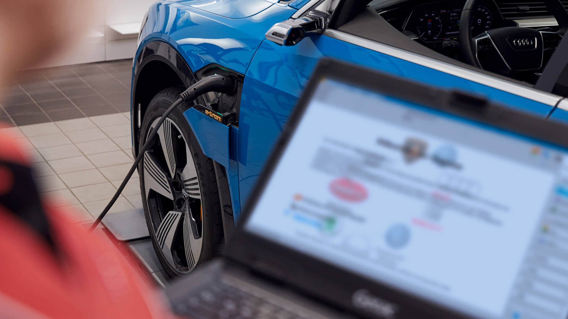 A blue Audi electric vehicle plugged in on charge at an Audi service centre 