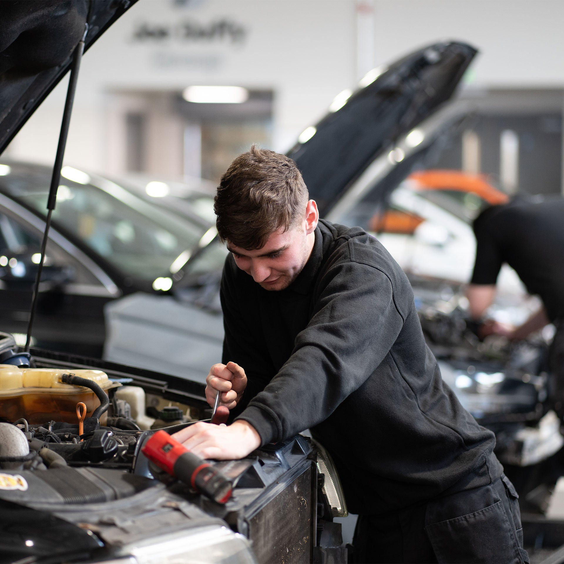 An Audi engineer working on a customer car