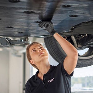 A mechanic sitting in a car while looking at a computer screen