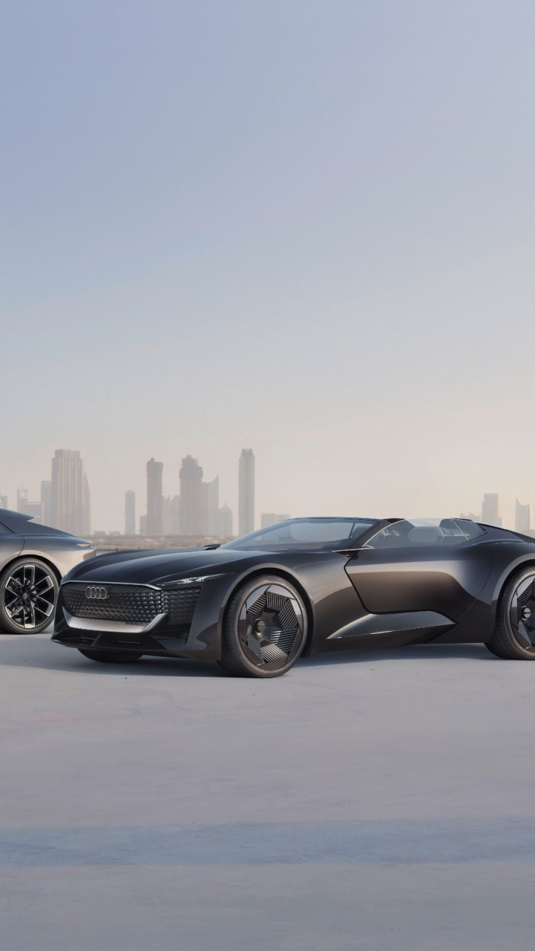 Three Audi vehicles alongside one another with a cityscape in the background