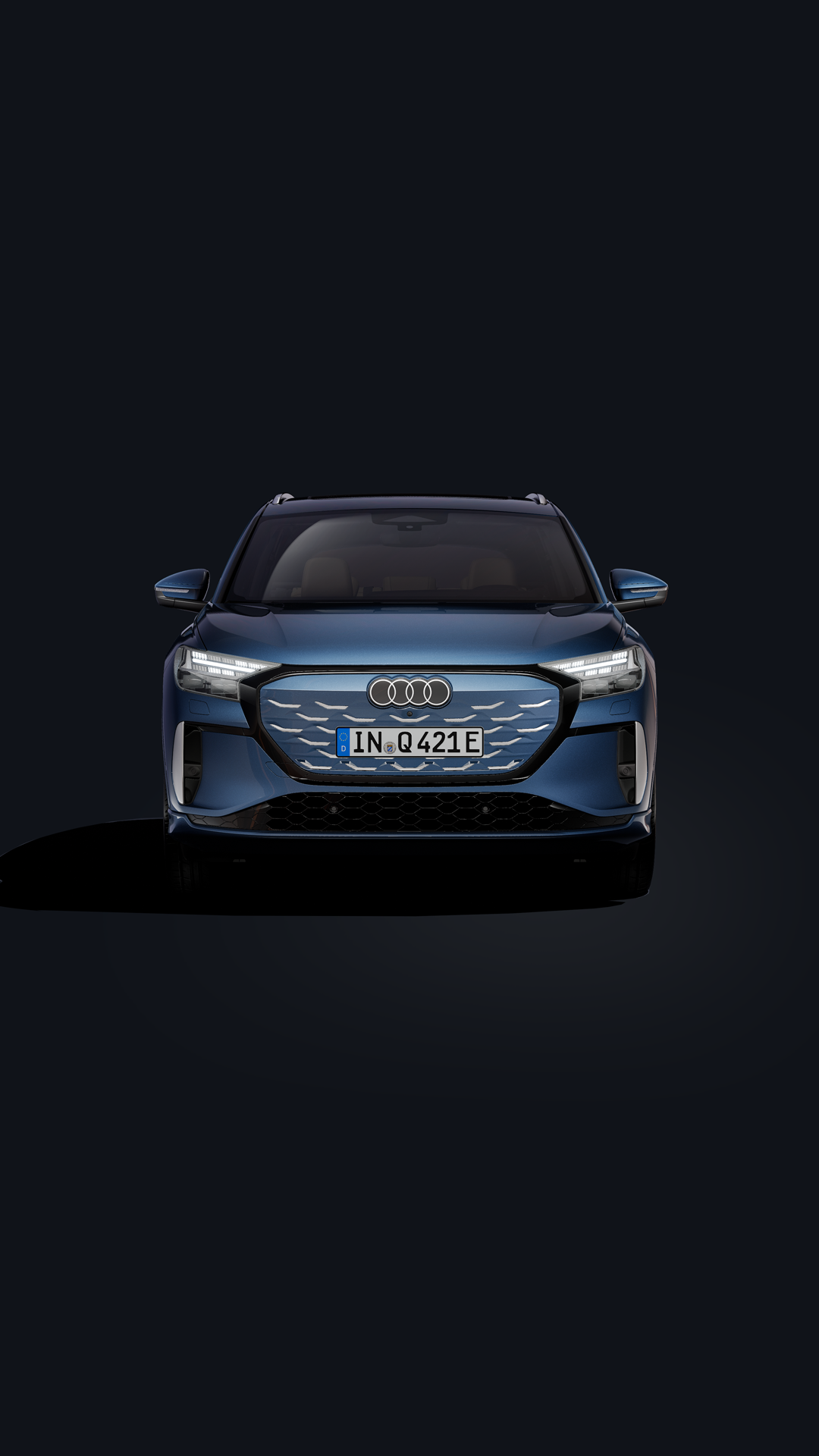 The Q4 SUV e-tron, viewed from the front at an angle against a dark background.