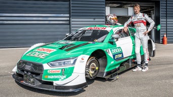 Nico Müller stands next to the Audi RS 5 DTM