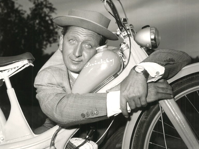 Black and white photo of a man in a hat embracing the NSU Quickly