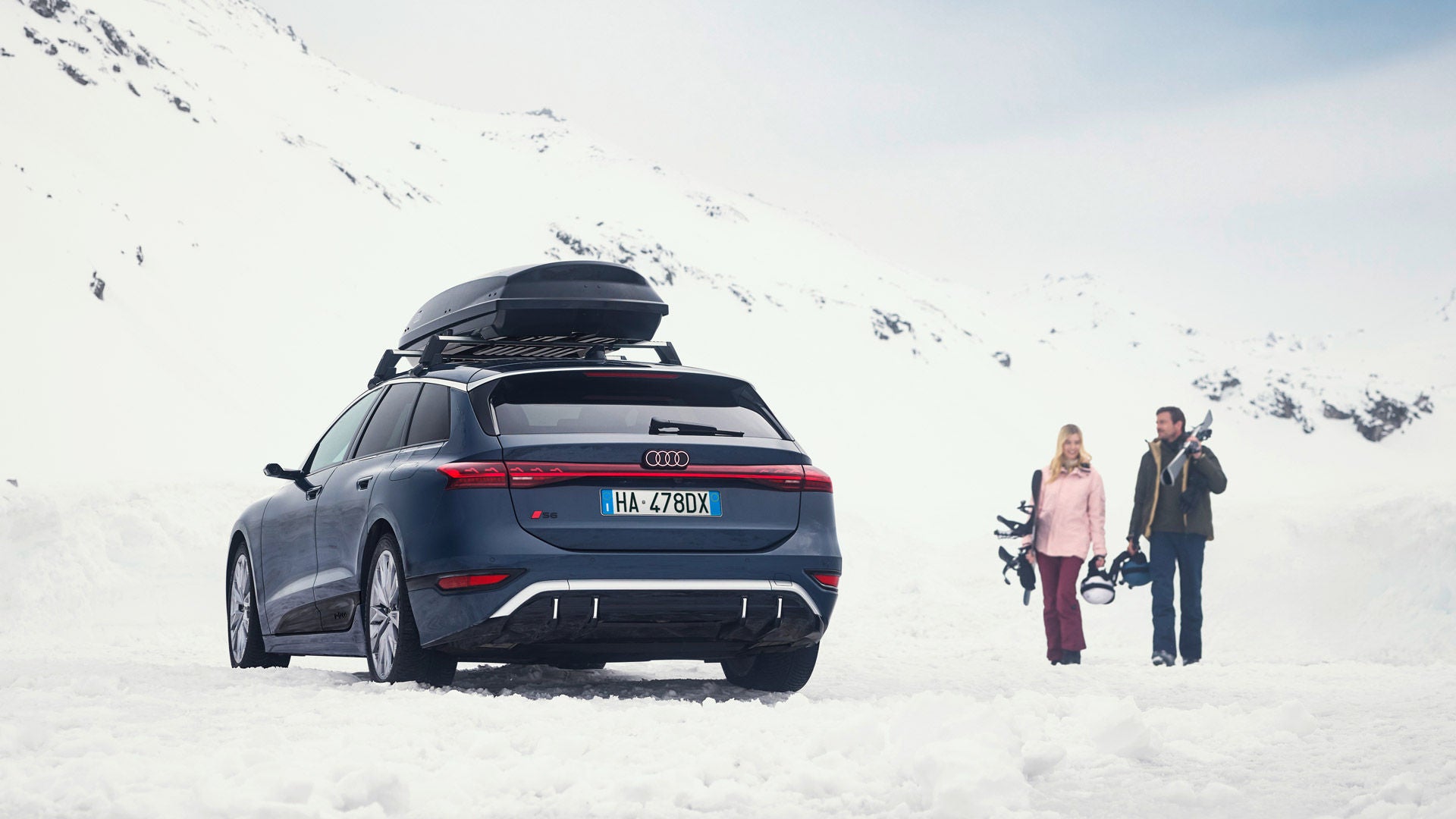 Un’Audi equipaggiata con Accessori Invernali Audi, con ruote complete invernali e porta sci montato sul tetto.